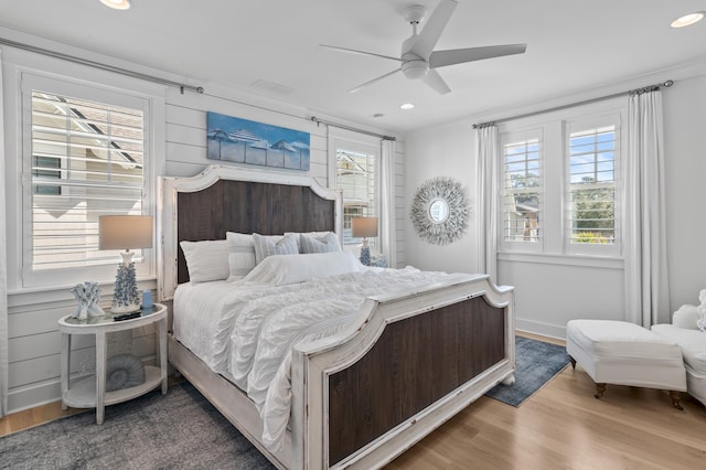 bedroom with ceiling fan, ornamental molding, and wood-type flooring