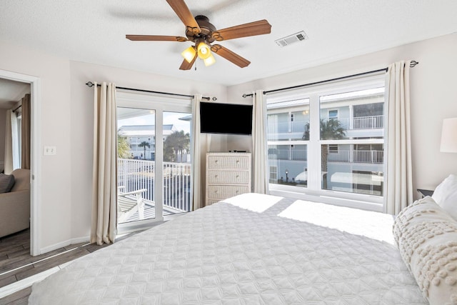 bedroom featuring hardwood / wood-style flooring, ceiling fan, a textured ceiling, and access to outside