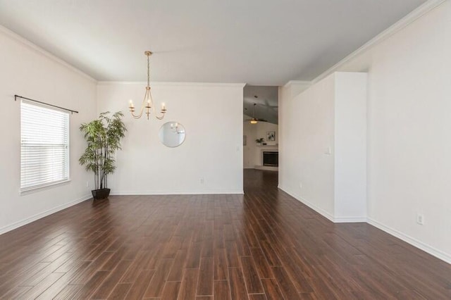 empty room featuring an inviting chandelier, dark hardwood / wood-style flooring, and crown molding