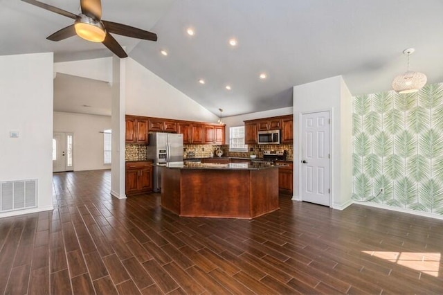 kitchen featuring appliances with stainless steel finishes, a center island, pendant lighting, and dark hardwood / wood-style flooring