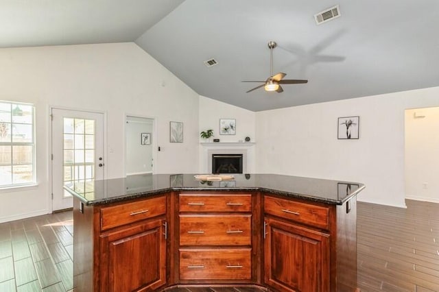 kitchen with lofted ceiling, dark wood-type flooring, a center island, and ceiling fan