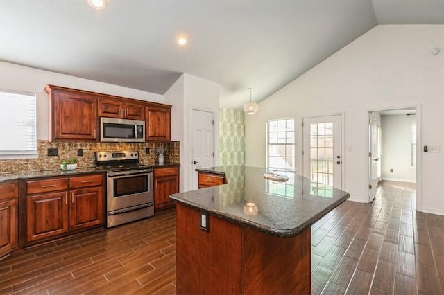 kitchen featuring tasteful backsplash, a center island, high vaulted ceiling, dark stone counters, and stainless steel appliances