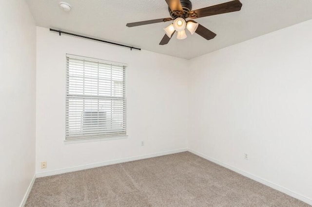 spare room with light colored carpet and ceiling fan