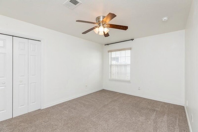 unfurnished bedroom featuring light carpet, a closet, and ceiling fan