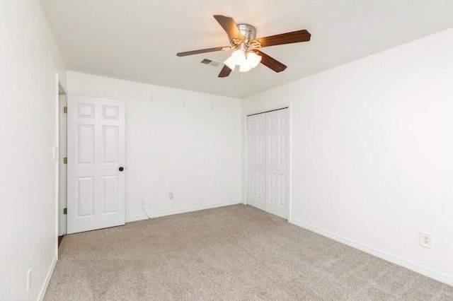 unfurnished bedroom with ceiling fan, light colored carpet, and a closet