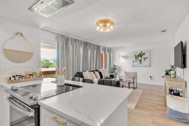 kitchen featuring white cabinetry, light hardwood / wood-style flooring, light stone counters, and stainless steel range with electric stovetop