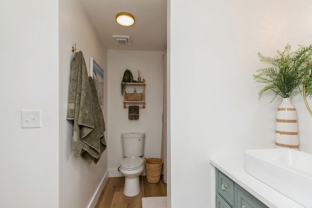 bathroom with vanity, hardwood / wood-style floors, and toilet