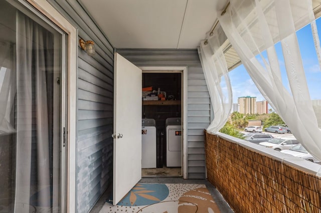 view of exterior entry with washer and dryer and a balcony