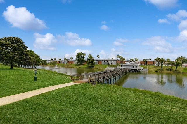 dock area with a water view and a yard