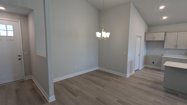 kitchen featuring pendant lighting, an inviting chandelier, and light hardwood / wood-style flooring