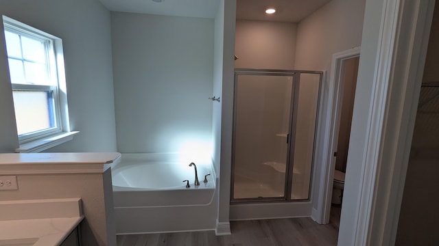 full bathroom with independent shower and bath, vanity, hardwood / wood-style flooring, and toilet