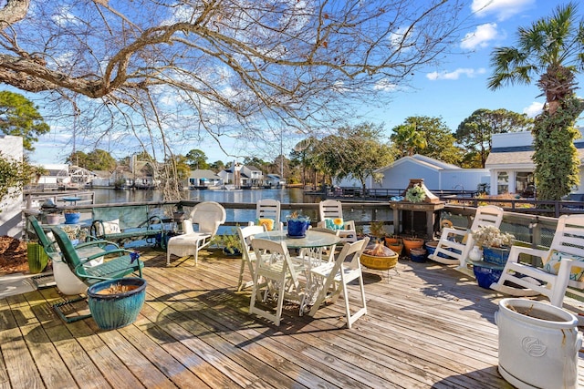 wooden deck with a water view and an outdoor fire pit