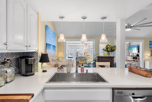 kitchen with vaulted ceiling, sink, white cabinets, hanging light fixtures, and stainless steel dishwasher