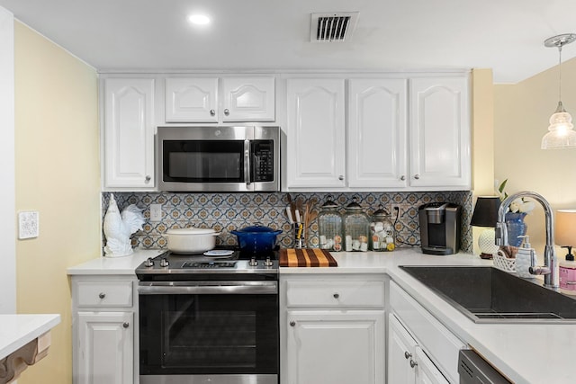 kitchen featuring pendant lighting, sink, stainless steel appliances, and white cabinets