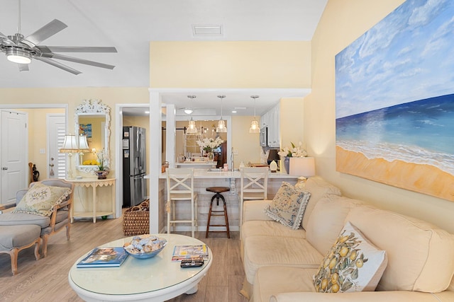 living room with light hardwood / wood-style flooring and ceiling fan