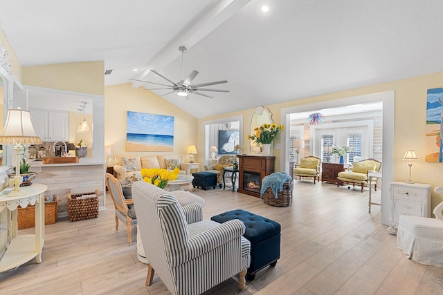 living room with vaulted ceiling with beams, ceiling fan, and light wood-type flooring