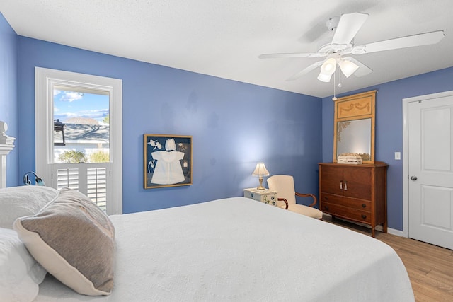 bedroom with ceiling fan, access to exterior, and light hardwood / wood-style floors