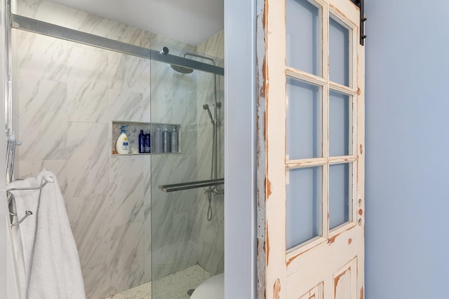 bathroom with a shower with door