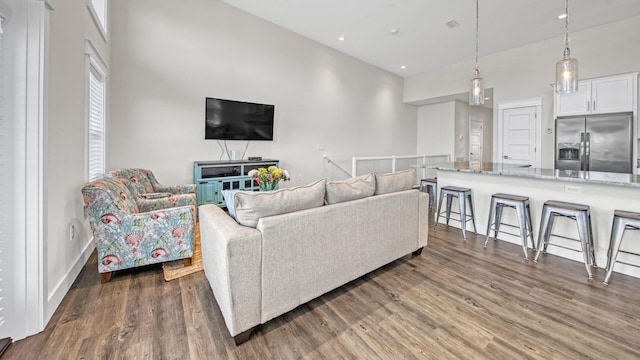 living room featuring dark wood-type flooring and a high ceiling