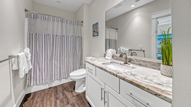 full bathroom featuring hardwood / wood-style flooring, vanity, toilet, and shower / bath combo