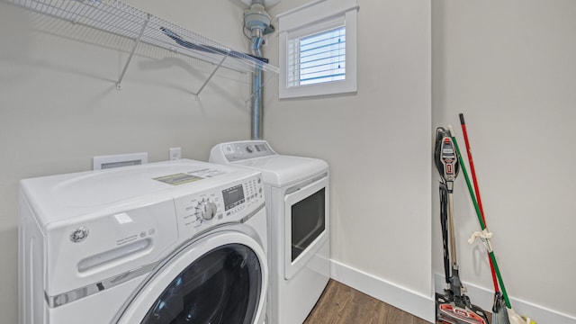 clothes washing area with dark wood-type flooring and washer and dryer