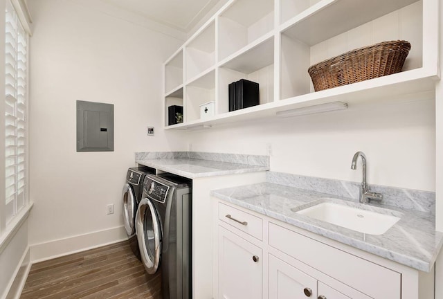 laundry area featuring dark wood-type flooring, washing machine and clothes dryer, sink, crown molding, and electric panel