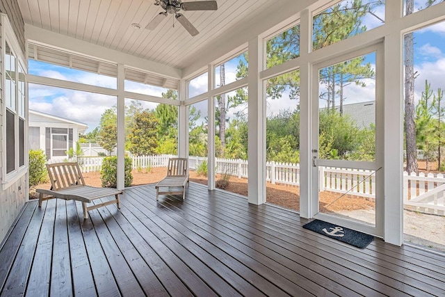 unfurnished sunroom featuring ceiling fan, wooden ceiling, and a healthy amount of sunlight