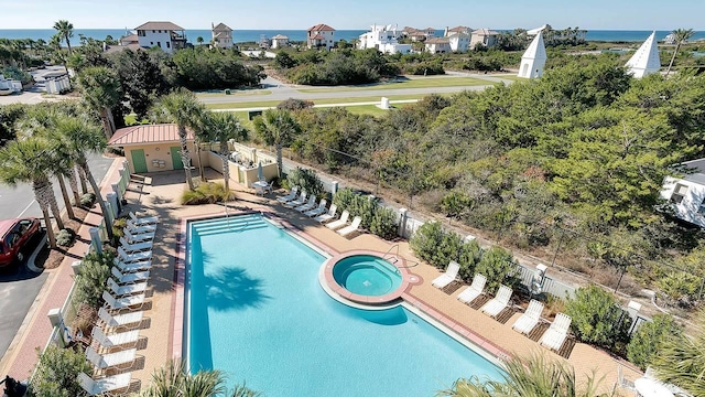 view of swimming pool with a patio area, a community hot tub, and a water view