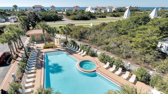 view of pool with a water view, a hot tub, and a patio