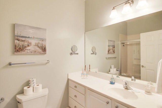 bathroom with vanity, toilet, and a shower with shower door