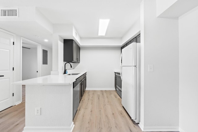 kitchen with stainless steel appliances, kitchen peninsula, sink, and light wood-type flooring