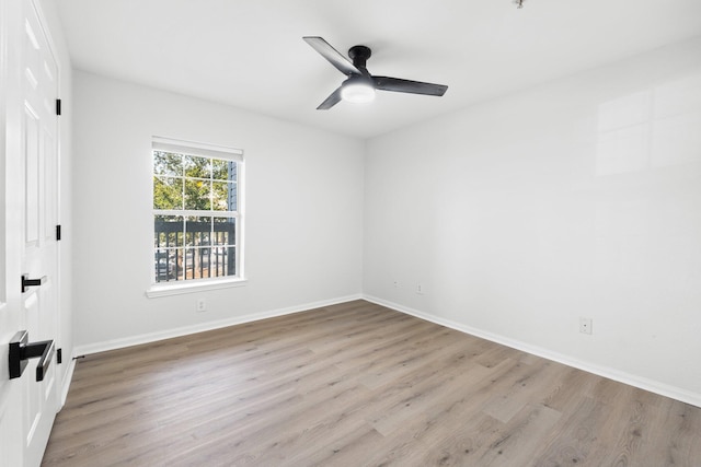 empty room with ceiling fan and light hardwood / wood-style flooring