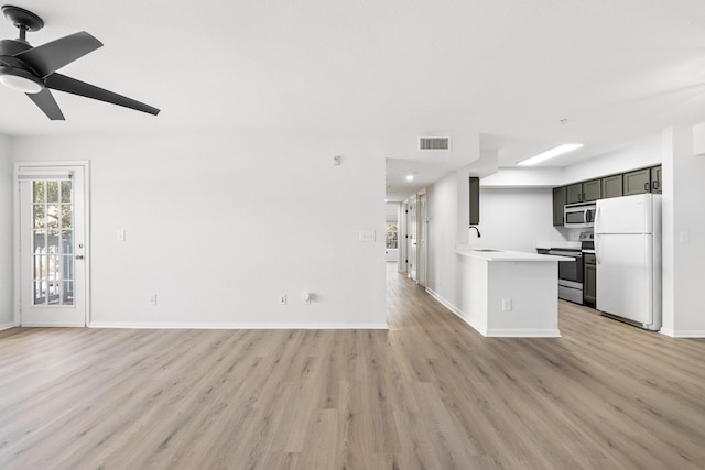 kitchen featuring sink, light hardwood / wood-style floors, ceiling fan, and appliances with stainless steel finishes