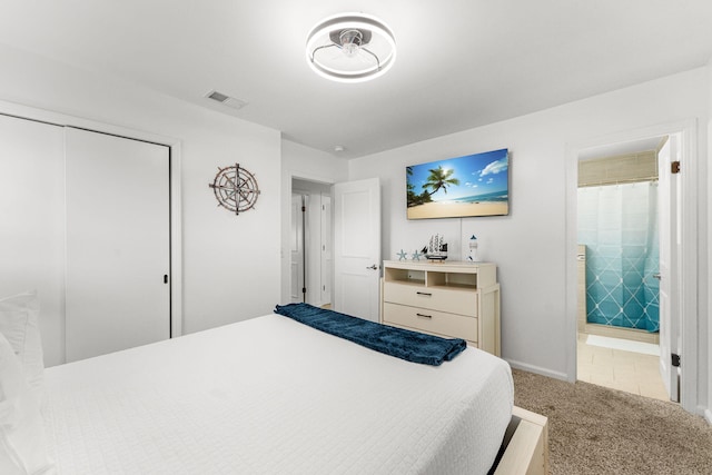 bedroom featuring light colored carpet, connected bathroom, and a closet