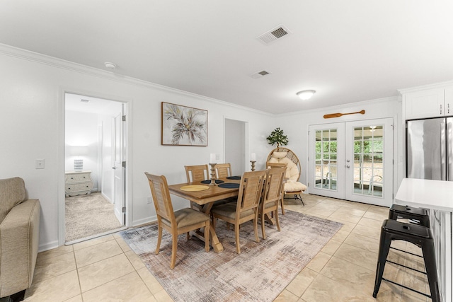 dining area with crown molding, french doors, and light tile patterned flooring