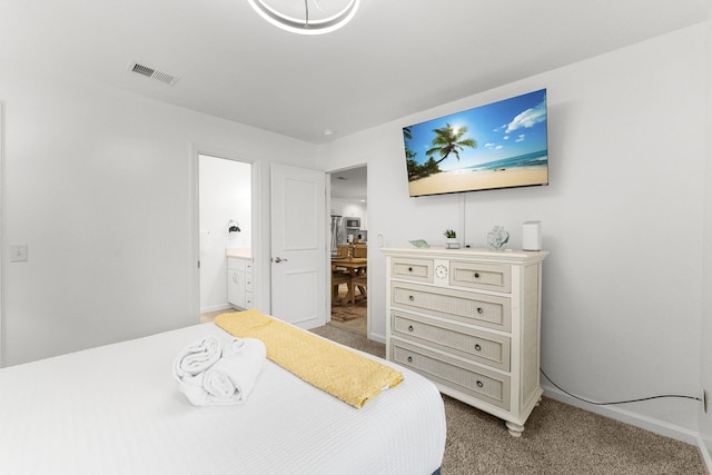 bedroom featuring connected bathroom and light carpet