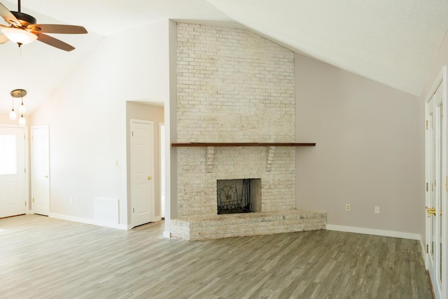 unfurnished living room featuring wood-type flooring, high vaulted ceiling, ceiling fan, and a fireplace