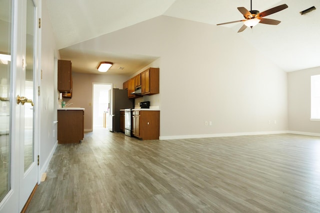 unfurnished living room featuring ceiling fan, vaulted ceiling, and light hardwood / wood-style floors