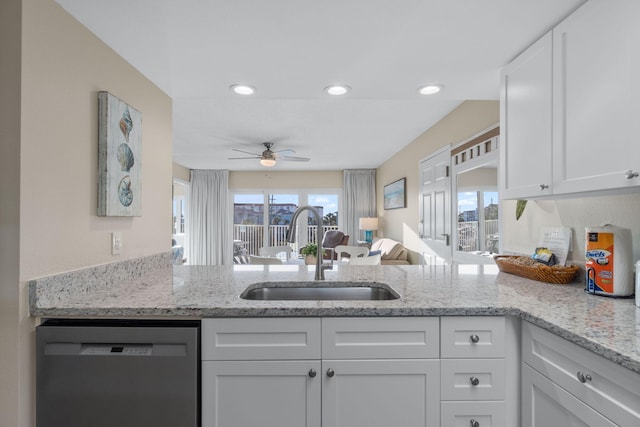 kitchen featuring white cabinetry, sink, stainless steel dishwasher, and kitchen peninsula