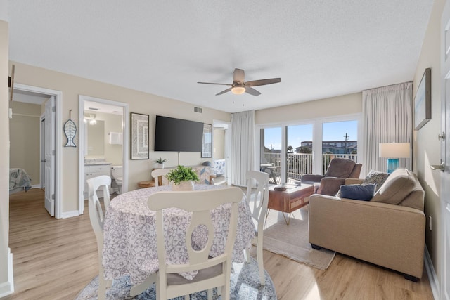 dining space with a textured ceiling, light hardwood / wood-style flooring, and ceiling fan