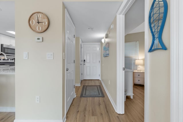 corridor with light hardwood / wood-style flooring