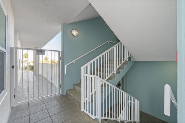 stairway with expansive windows and a textured ceiling