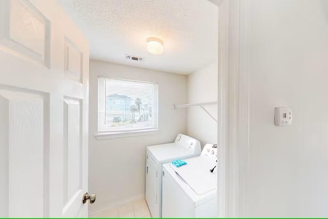 laundry room featuring washer and clothes dryer and a textured ceiling