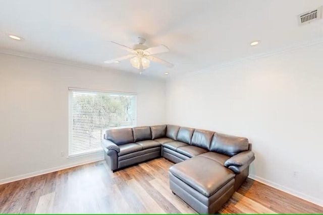 living room featuring crown molding, ceiling fan, and light hardwood / wood-style floors