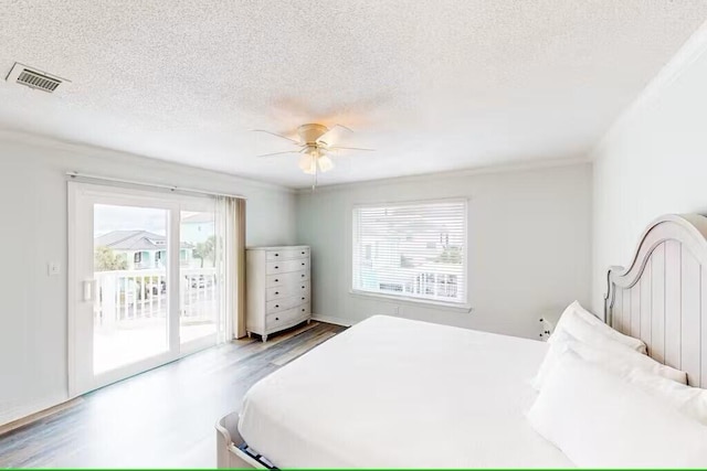 bedroom featuring ceiling fan, wood-type flooring, a textured ceiling, and access to outside