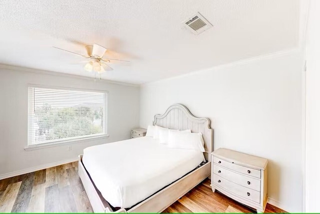 bedroom with a textured ceiling, light hardwood / wood-style flooring, and ceiling fan