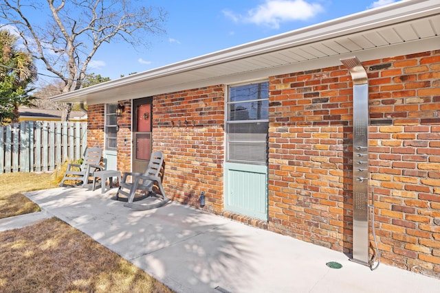 view of exterior entry with a patio