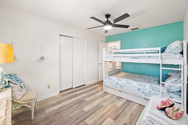 bedroom with light hardwood / wood-style floors, a closet, and ceiling fan