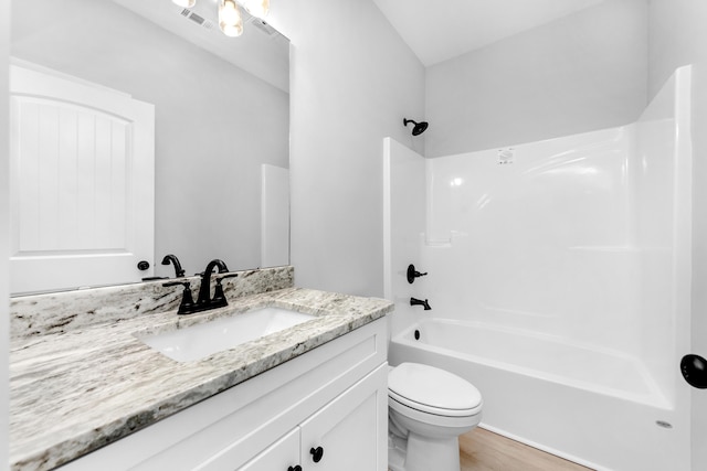 bathroom with visible vents, toilet, wood finished floors, vanity, and washtub / shower combination