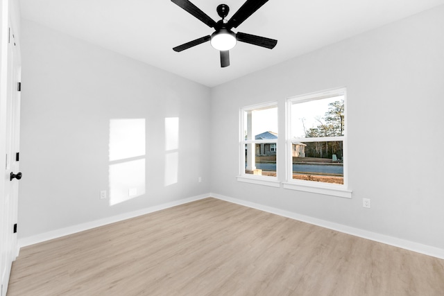 empty room featuring ceiling fan, baseboards, and wood finished floors